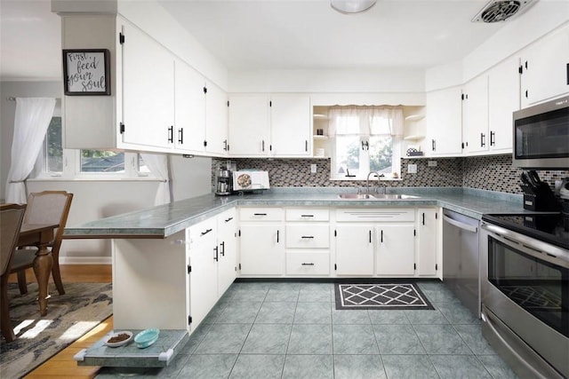 16 Grace Rd, Scottdale, PA 15683 - kitchen featuring appliances with stainless steel finishes, plenty of natural light, open shelves, and decorative backsplash