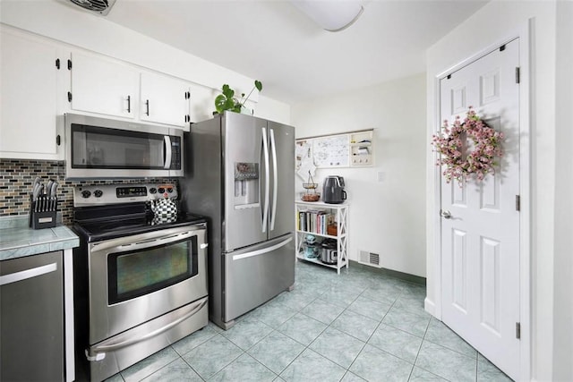 16 Grace Rd, Scottdale, PA 15683 - kitchen featuring appliances with stainless steel finishes, white cabinets, light tile patterned flooring, backsplash, and light countertops