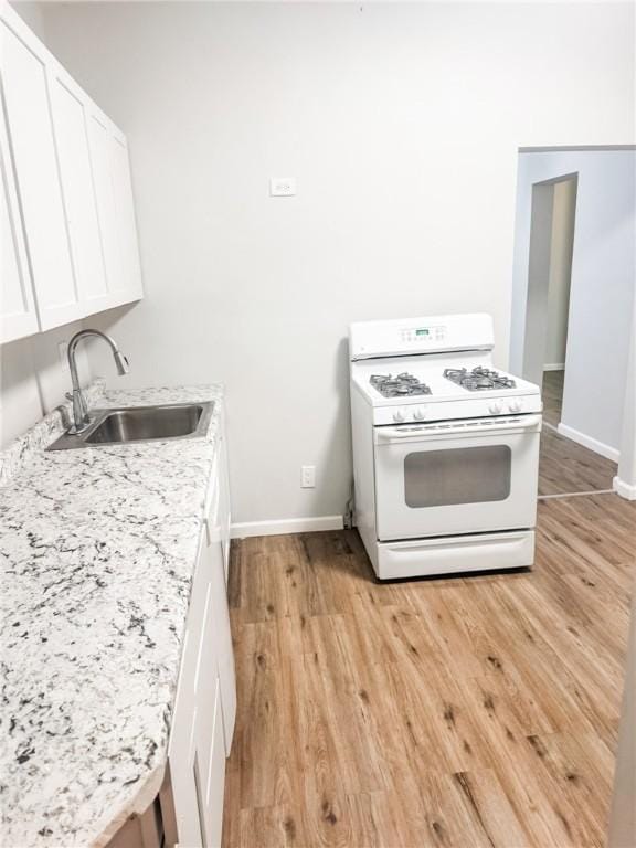7 Prospect St, Etna, PA 15223 - kitchen featuring gas range gas stove, light wood finished floors, and white cabinets