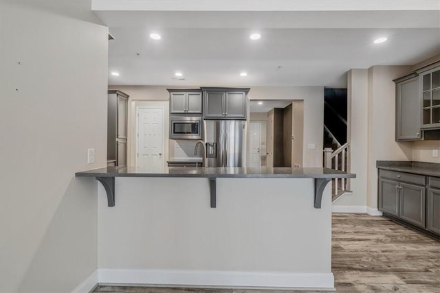 441 Roebling Ct, Cranberry Twp, PA 16066 - kitchen with appliances with stainless steel finishes, gray cabinetry, light wood finished floors, a kitchen breakfast bar, and recessed lighting