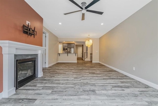 441 Roebling Ct, Cranberry Twp, PA 16066 - unfurnished living room featuring a ceiling fan, a glass covered fireplace, wood finished floors, and recessed lighting