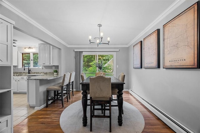 124 Heath Dr, Economy, PA 15005 - dining room featuring a baseboard heating unit, a chandelier, healthy amount of natural light, crown molding, and wood finished floors