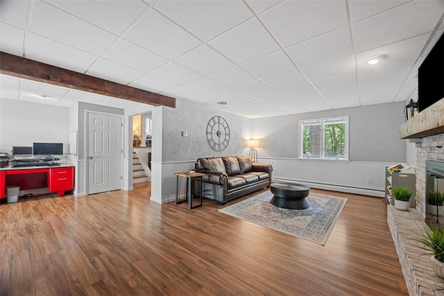 124 Heath Dr, Economy, PA 15005 - living area featuring stairway, wood finished floors, a baseboard heating unit, wainscoting, and a brick fireplace