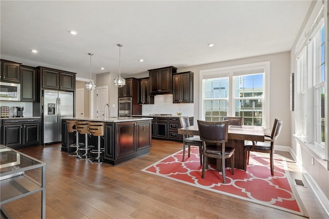 1735 Stevensan Dr, Franklin Park, PA 15143 - kitchen featuring stainless steel appliances, healthy amount of natural light, a breakfast bar, wood finished floors, and recessed lighting