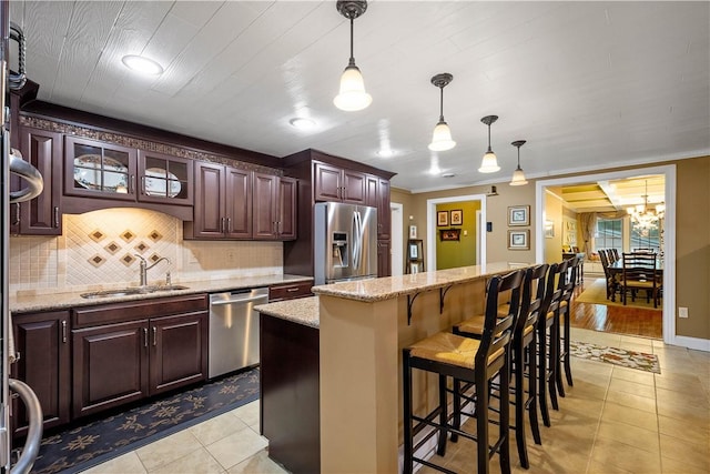102 Klages Rd, Donegal, PA 15376 - kitchen with stainless steel appliances, light tile patterned flooring, decorative backsplash, a breakfast bar area, and hanging light fixtures
