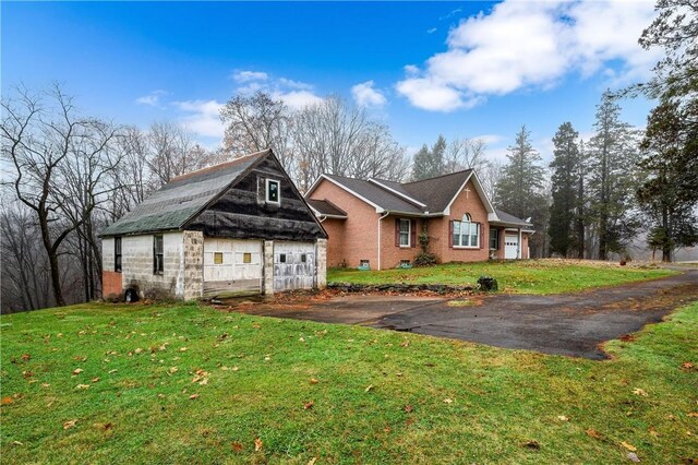 1664 N Main St, Center Twp, PA 16001 - view of front facade featuring an outbuilding, a front lawn, brick siding, and a garage