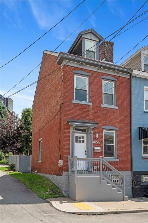 4228 Post St, Lawrenceville, PA 15201 - view of front of home featuring brick siding and a chimney