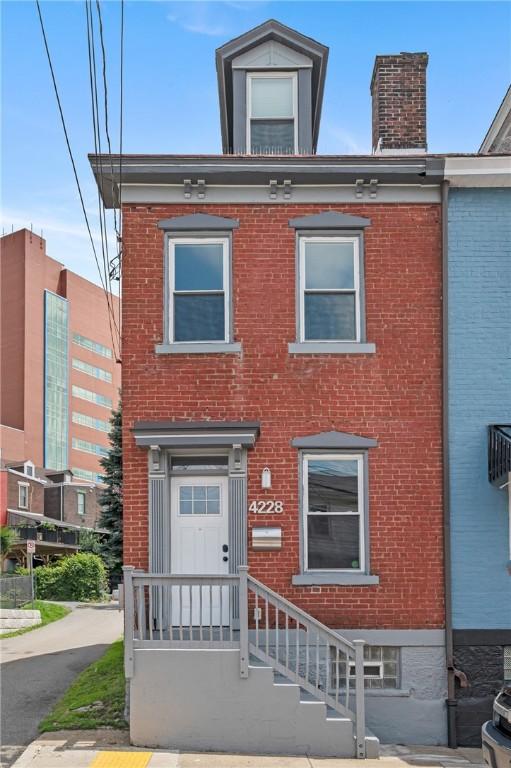 4228 Post St, Lawrenceville, PA 15201 - view of front of property with brick siding and a chimney