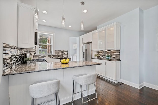 4228 Post St, Lawrenceville, PA 15201 - kitchen featuring stainless steel refrigerator with ice dispenser, washing machine and clothes dryer, decorative backsplash, dark wood-type flooring, and a peninsula