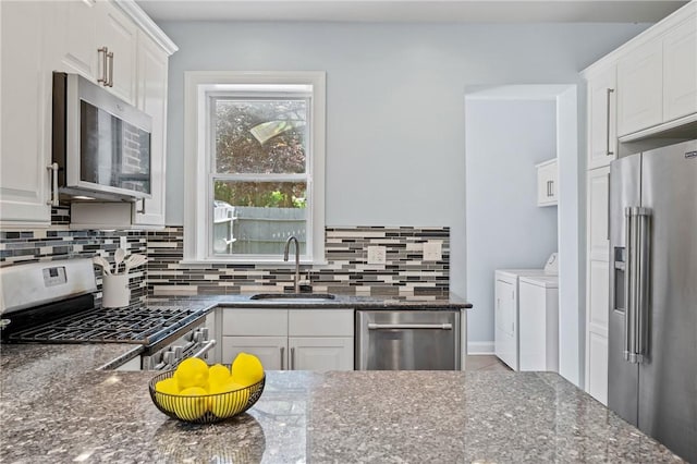 4228 Post St, Lawrenceville, PA 15201 - kitchen featuring appliances with stainless steel finishes, washer and clothes dryer, tasteful backsplash, and white cabinets