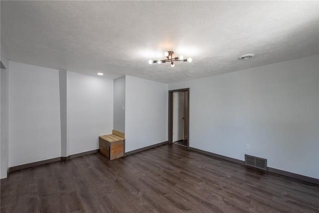 430 Kennedy Ave, East Vandergrift, PA 15629 - spare room featuring dark wood-type flooring, a chandelier, and a textured ceiling