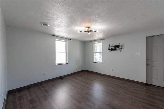 430 Kennedy Ave, East Vandergrift, PA 15629 - empty room featuring a textured ceiling, dark wood-type flooring, and a chandelier