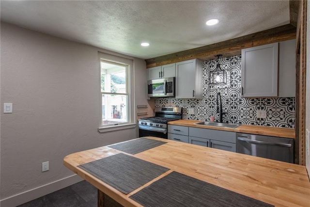 430 Kennedy Ave, East Vandergrift, PA 15629 - kitchen with butcher block counters, appliances with stainless steel finishes, a textured ceiling, decorative backsplash, and recessed lighting