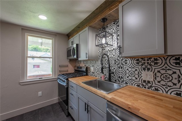 430 Kennedy Ave, East Vandergrift, PA 15629 - kitchen with stainless steel appliances, butcher block counters, tasteful backsplash, pendant lighting, and a textured ceiling