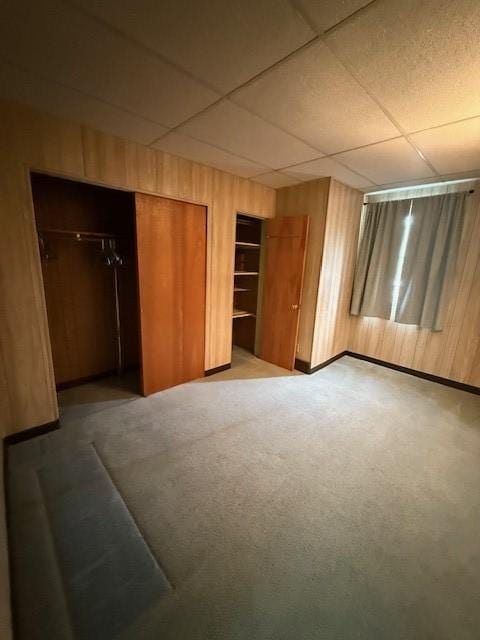 410 Hershey Rd, Penn Hills, PA 15235 - unfurnished bedroom with wooden walls, a drop ceiling, carpet, and two closets