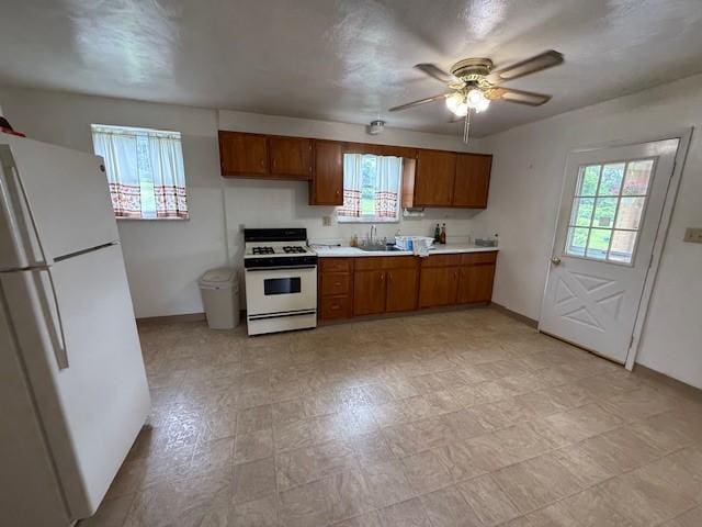 410 Hershey Rd, Penn Hills, PA 15235 - kitchen with white appliances, brown cabinets, a ceiling fan, and light countertops