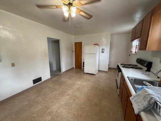 410 Hershey Rd, Penn Hills, PA 15235 - kitchen with white appliances, a ceiling fan, light flooring, brown cabinets, and light countertops