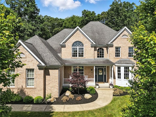 1023 Sophia Ln, Adams Twp, PA 16046 - traditional-style house featuring brick siding, a shingled roof, covered porch, and a front lawn