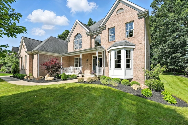 1023 Sophia Ln, Adams Twp, PA 16046 - view of front of home featuring brick siding, covered porch, a front yard, and roof with shingles