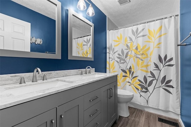 1608 Valley Brooke Ct, Franklin Park, PA 15090 - bathroom with a textured ceiling, double vanity, wood finished floors, and a shower with shower curtain