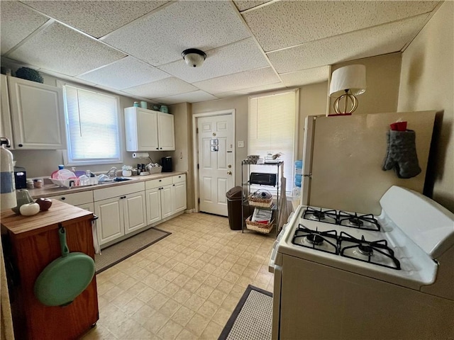 12 N Lee Ave, New Castle/6Th, PA 16101 - kitchen with white appliances, light flooring, white cabinetry, and a paneled ceiling
