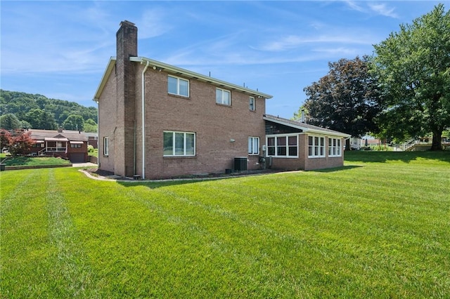 318 E Edgewood Ave, Trafford, PA 15085 - rear view of house featuring a chimney, a yard, and brick siding