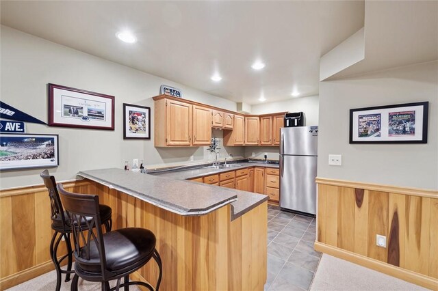 205 Elmhurst Cir, Cranberry Twp, PA 16066 - kitchen featuring freestanding refrigerator, a peninsula, a kitchen breakfast bar, wainscoting, and recessed lighting