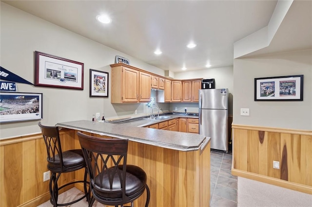 205 Elmhurst Cir, Cranberry Twp, PA 16066 - kitchen with freestanding refrigerator, a peninsula, wainscoting, a kitchen bar, and wood walls