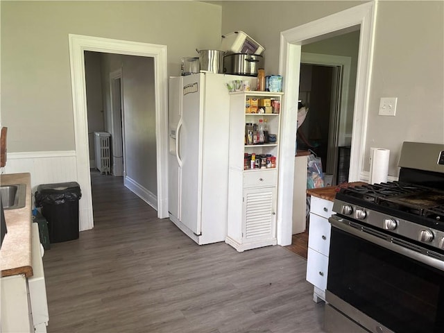 150 N Ave E, Pittsburgh, PA 15112 - kitchen with stainless steel gas range, dark wood-style flooring, radiator heating unit, white fridge with ice dispenser, and a wainscoted wall