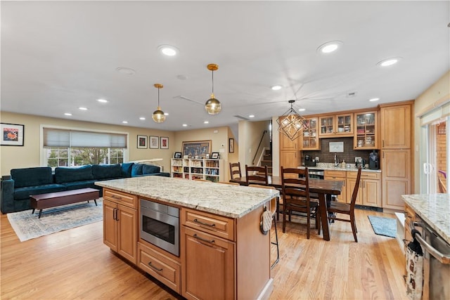 569 Pat Haven Dr, Mt Lebanon, PA 15243 - kitchen with stainless steel microwave, light wood-style flooring, recessed lighting, open floor plan, and hanging light fixtures