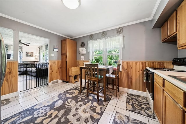 3640 Bakerstown Rd, Richland, PA 15044 - kitchen featuring white range with electric stovetop, wainscoting, plenty of natural light, light tile patterned floors, and wood walls