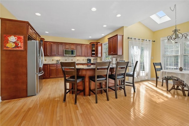 1100 Eleanor Pl, Adams Twp, PA 15044 - kitchen with stainless steel appliances, a skylight, light wood-style flooring, a peninsula, and a chandelier