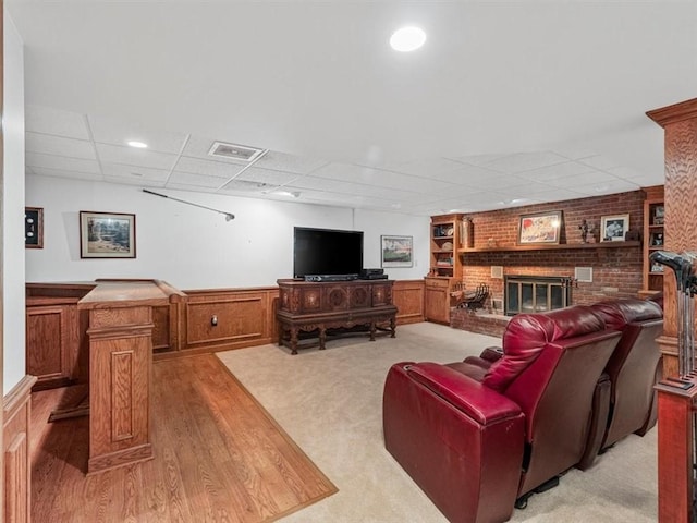 4273 River Rd, North Sewickley Twp, PA 15010 - living room featuring a fireplace, a drop ceiling, wainscoting, light wood-style flooring, and a decorative wall