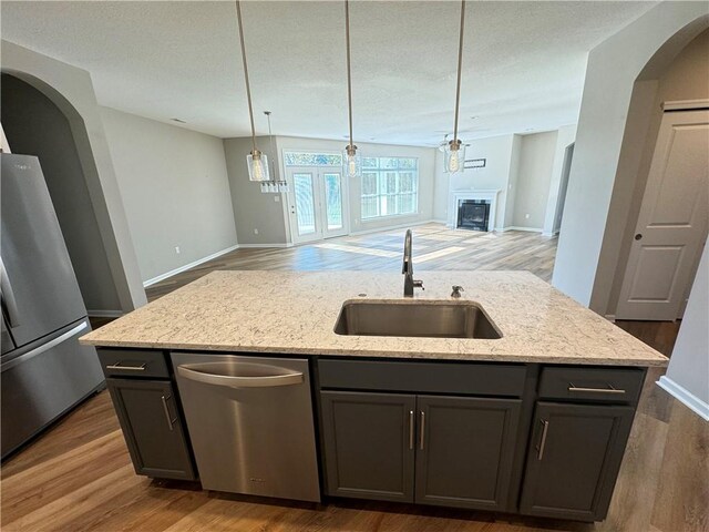 4252 Hawthorn Dr, South Park, PA 15129 - kitchen with stainless steel appliances, open floor plan, a kitchen island with sink, light stone countertops, and a glass covered fireplace