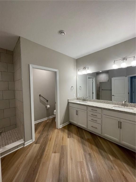 4252 Hawthorn Dr, South Park, PA 15129 - bathroom featuring a tile shower, double vanity, and wood finished floors