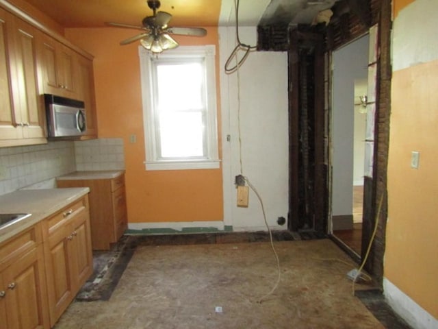 255 Duncan Ave, City Of Washington, PA 15301 - kitchen with stainless steel microwave, backsplash, ceiling fan, light countertops, and brown cabinets