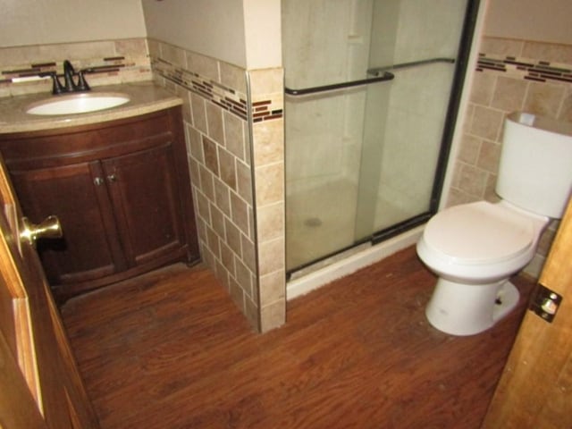 458 Wendel Rd, Hempfield Twp, PA 15642 - bathroom with tile walls, wood finished floors, a stall shower, vanity, and wainscoting