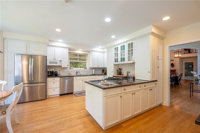 16 Mcdowell Rd, Ligonier Twp, PA 15658 - kitchen with stainless steel appliances, dark countertops, light wood-style floors, a chandelier, and tasteful backsplash