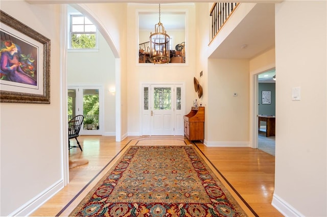 16 Mcdowell Rd, Ligonier Twp, PA 15658 - entrance foyer featuring a chandelier, light wood-type flooring, arched walkways, and a high ceiling