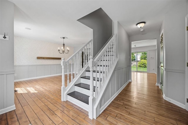 116 Stonegate Dr, North Strabane, PA 15317 - stairway featuring wood finished floors, a chandelier, a decorative wall, and wainscoting
