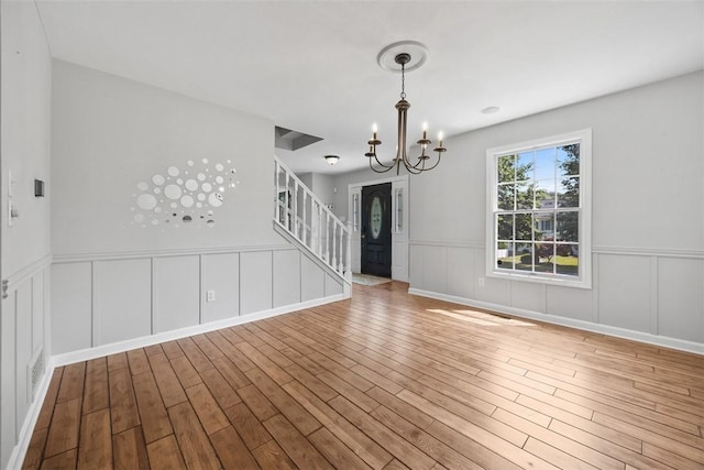 116 Stonegate Dr, North Strabane, PA 15317 - spare room with wood finished floors, stairs, a chandelier, a wainscoted wall, and a decorative wall