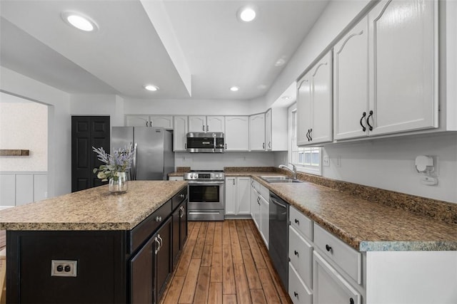 116 Stonegate Dr, North Strabane, PA 15317 - kitchen with stainless steel appliances, a kitchen island, white cabinetry, recessed lighting, and wood finished floors