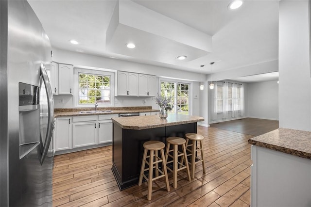 116 Stonegate Dr, North Strabane, PA 15317 - kitchen with stainless steel fridge with ice dispenser, light wood finished floors, a center island, white cabinetry, and recessed lighting