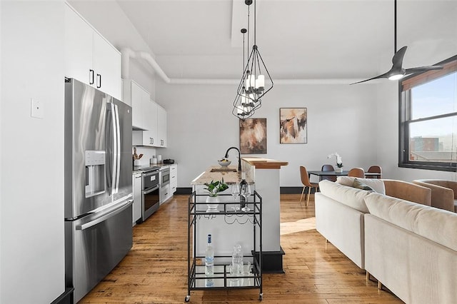 3080 Smallman St, Downtown Pgh, PA 15201 - kitchen featuring stainless steel appliances, white cabinetry, open floor plan, wood finished floors, and hanging light fixtures