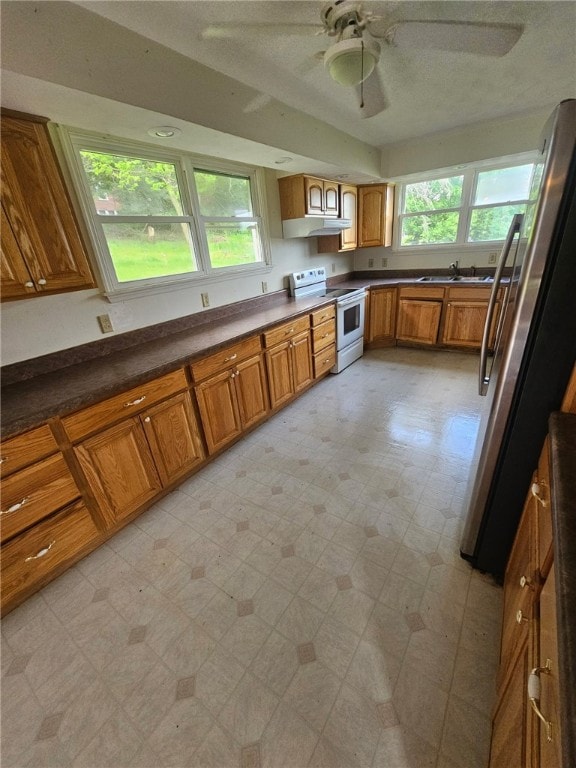 120 Upper Clinton St, Canoe/Banks Twps, PA 15772 - kitchen featuring white range with electric stovetop, brown cabinetry, exhaust hood, light floors, and freestanding refrigerator