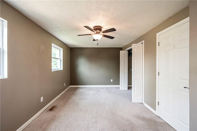 221 Wheatfield Dr, Hempfield Twp, PA 15601 - unfurnished bedroom with a textured ceiling, light carpet, and a ceiling fan