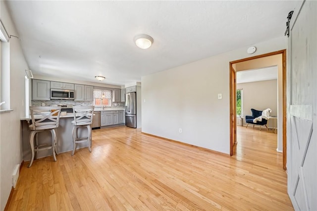 1533 Missouri Ave, South Park, PA 15017 - kitchen with stainless steel appliances, gray cabinets, light wood-type flooring, a peninsula, and a breakfast bar