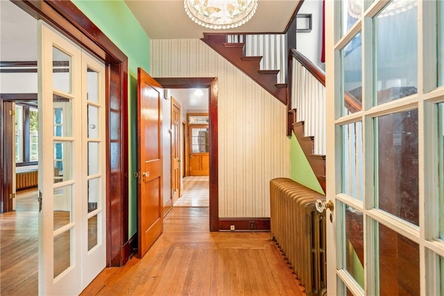 429 S Center Ave, Somerset Boro, PA 15501 - hallway featuring radiator heating unit, french doors, light wood-style flooring, and a chandelier