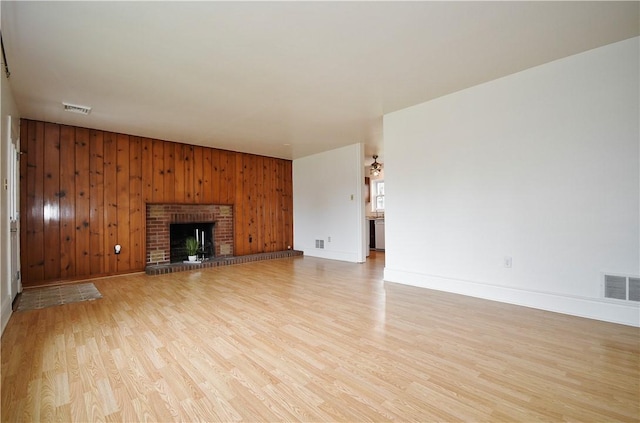 126 S Patton Dr, Moon/Crescent Twp, PA 15108 - unfurnished living room with light wood-type flooring, wood walls, and a fireplace