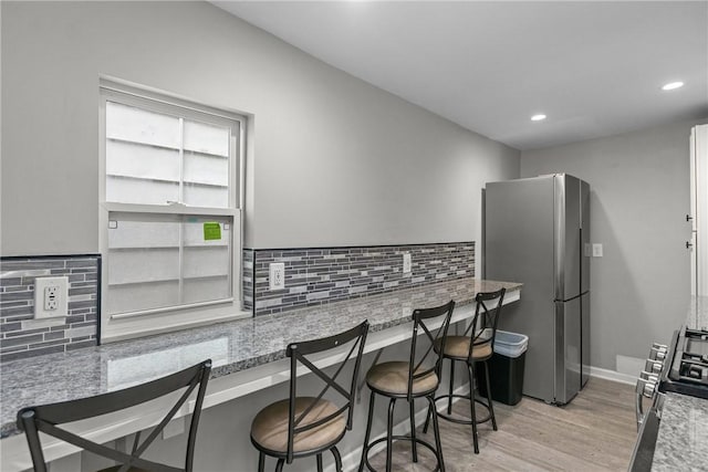 1022 2nd Ave, Coraopolis, PA 15108 - kitchen featuring stainless steel appliances, light wood-type flooring, backsplash, recessed lighting, and a kitchen breakfast bar